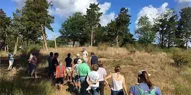 Group of people gathered outdoors in a grassy field