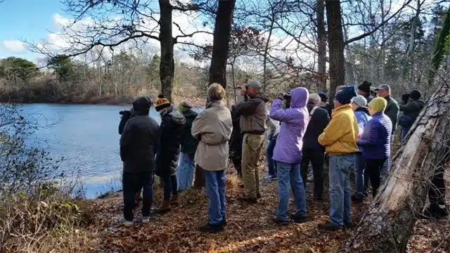 Group of people gathered by a lakeside