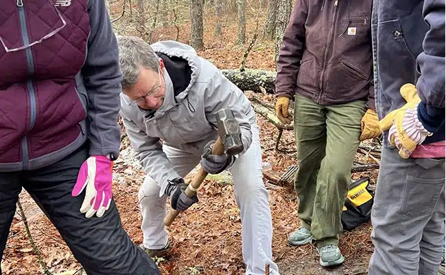 People using hand tools during a trail maintenance project